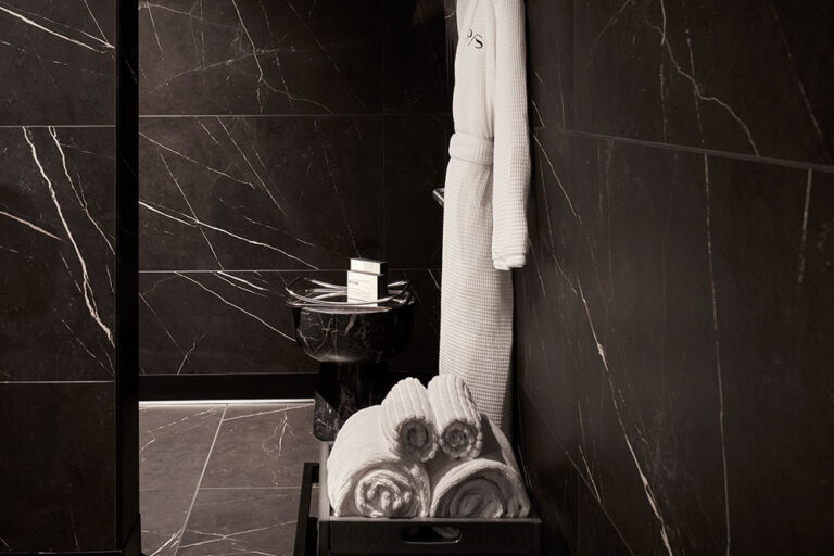 Private bathroom view with folded robes and hanging robe.